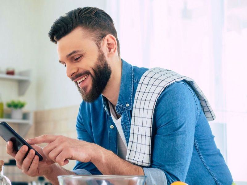 Mann mit Smartphone in der KÃ¼che