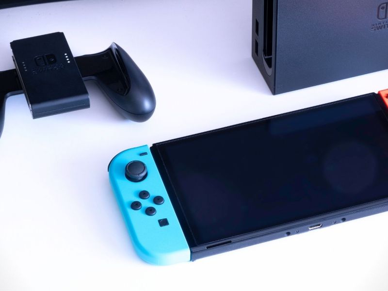 Eine Nintendo Switch auf einem Tisch mit Zubehör und Dockingstation.