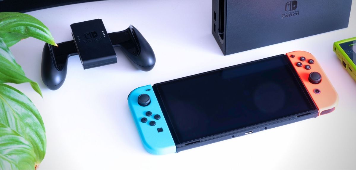 Eine Nintendo Switch auf einem Tisch mit Zubehör und Dockingstation.