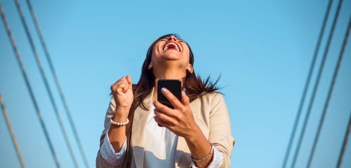 Frau mit Smartphone freut sich