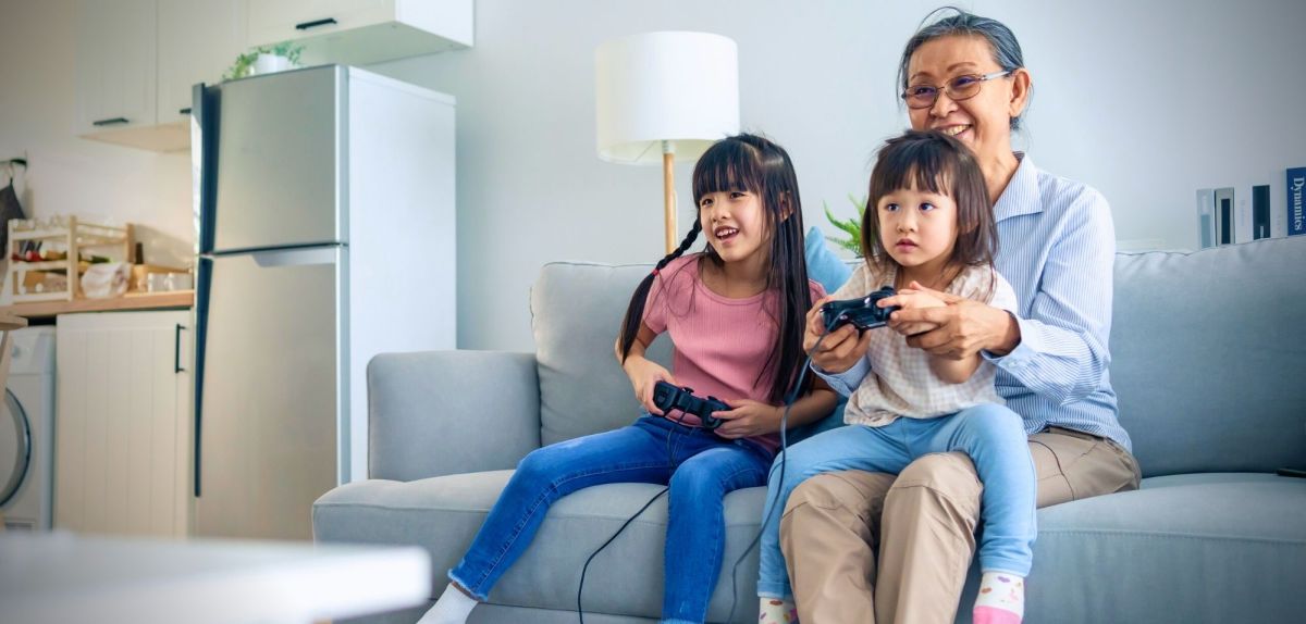 Oma spielt mit Enkelkindern Videospiele