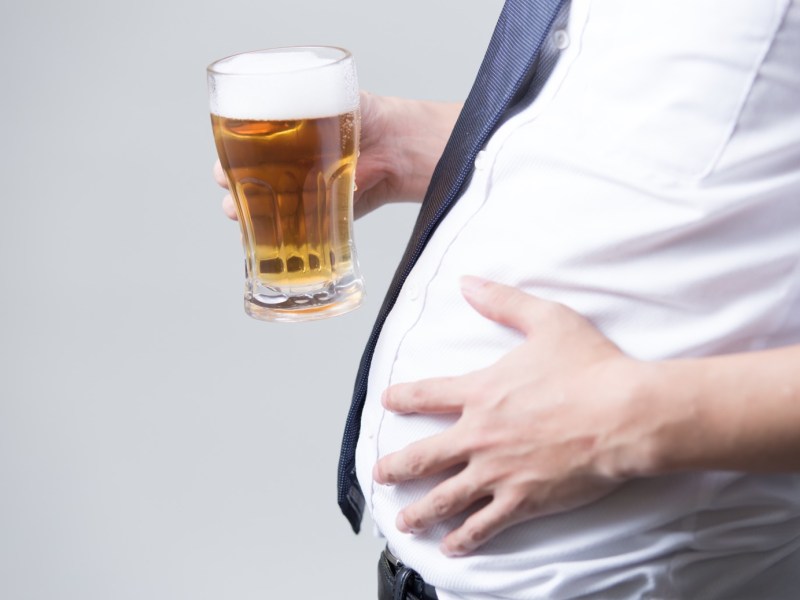 Mann mit Bier in der Hand und Bierbauch