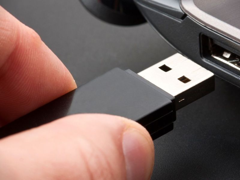 Person will USB-Stick in PC schieben