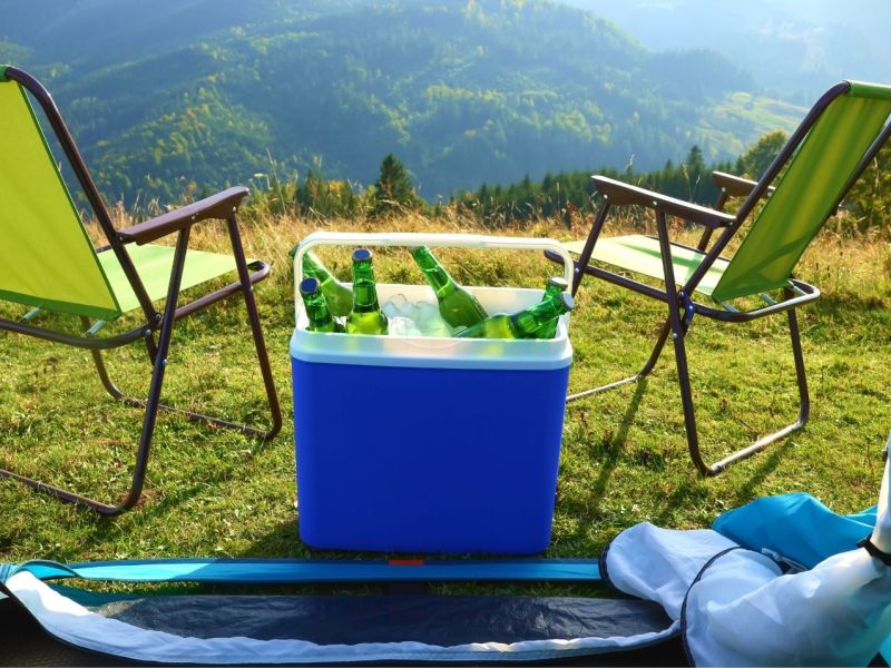 Camping-Kühlbox am Zelt mit Camping-Stühlen