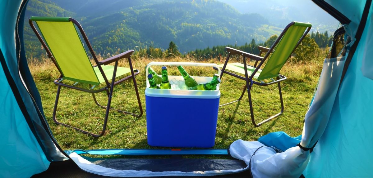 Camping-Kühlbox am Zelt mit Camping-Stühlen