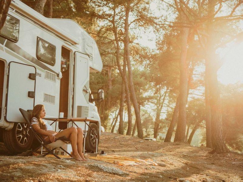 Frau campt nachhaltig im Wald mit Wohnmobil