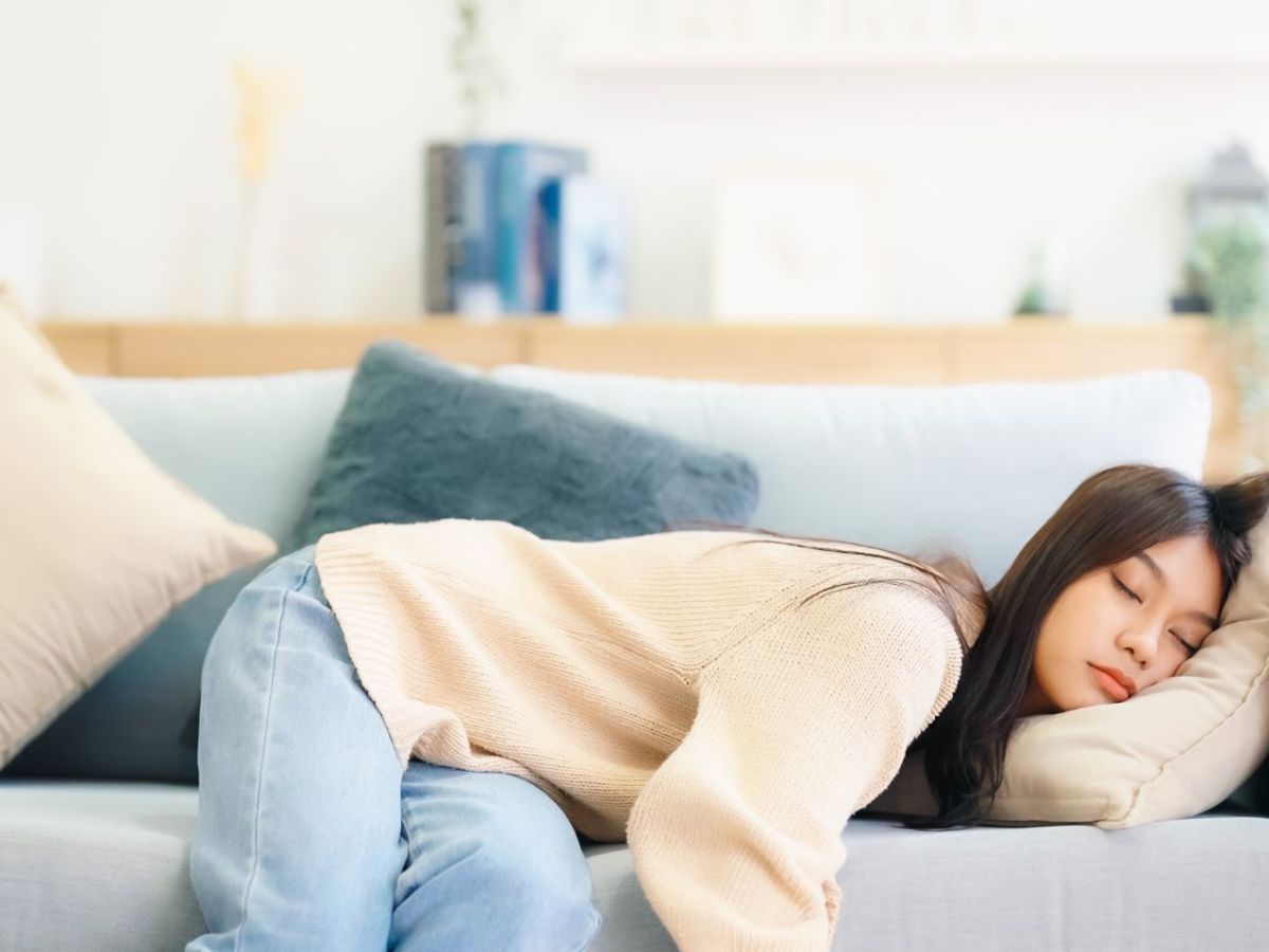 Frau hÃ¤lt auf einem Sofa ein Nickerchen.