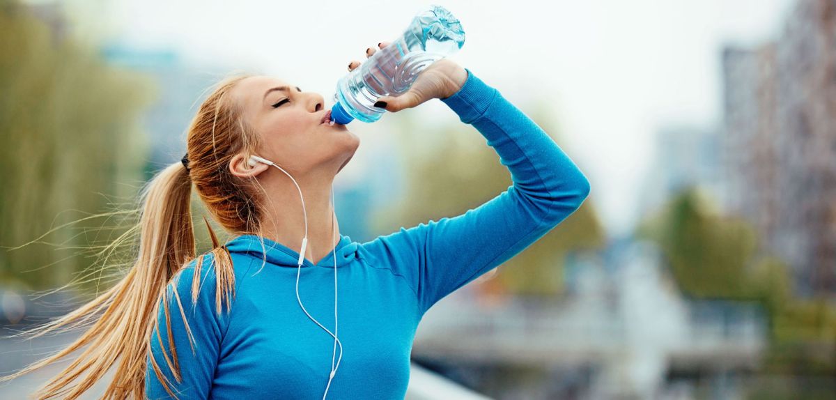 Frau trinkt Mineralwasser aus der Flasche