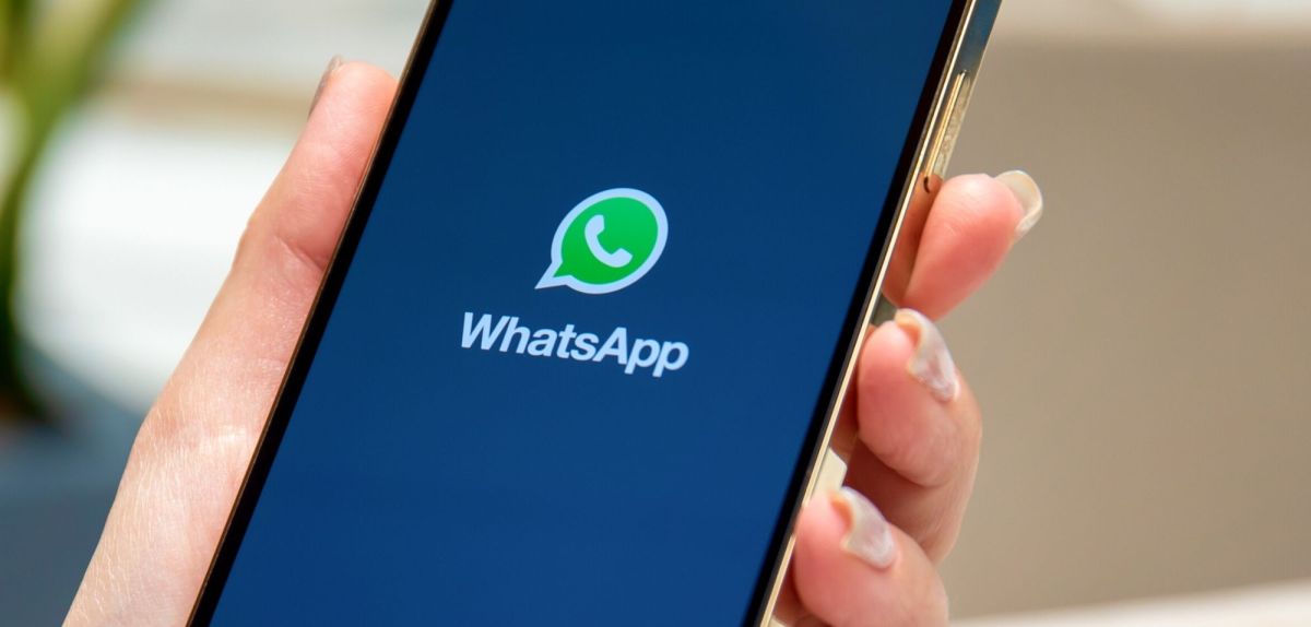 Person hält Handy mit WhatsApp in der Hand.