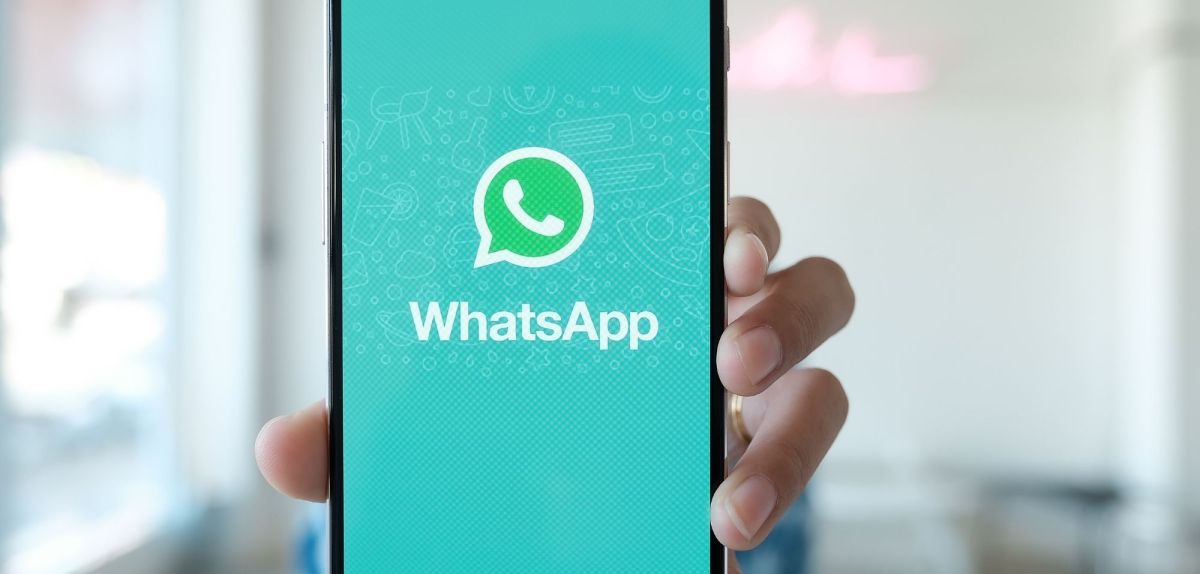 Person hält Handy mit WhatsApp in die Kamera.