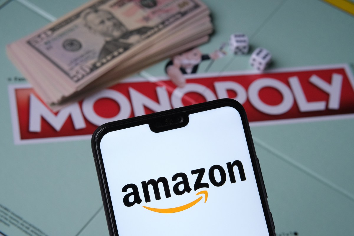 Amazon Logo erscheint auf Smartphone vor einem Monopoly-Spiel