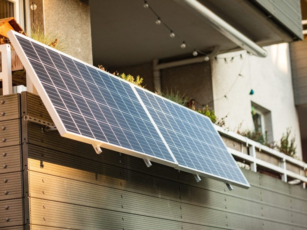 Zwei Solarpanele sind an einem Balkon montiert.
