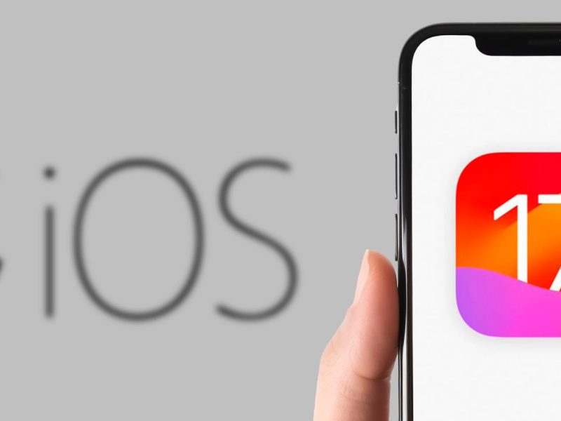 Ein iPhone mit iOS 17 vor einem riesigen Apple-Logo gehalten.