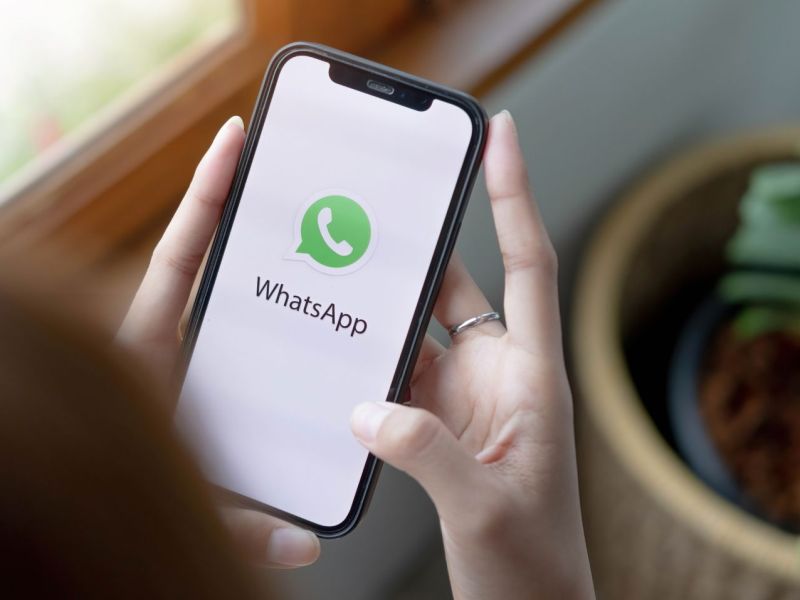 Frau öffnet WhatsApp auf dem Handy