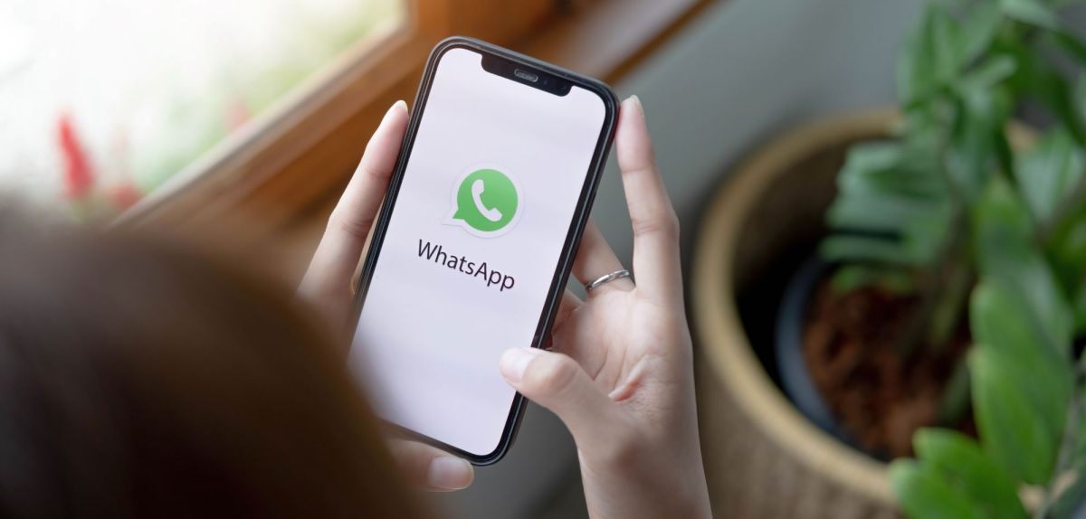 Frau öffnet WhatsApp auf dem Handy