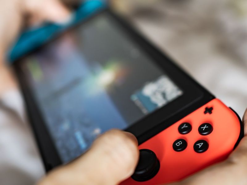 Person hält eine Nintendo Switch in Händen.