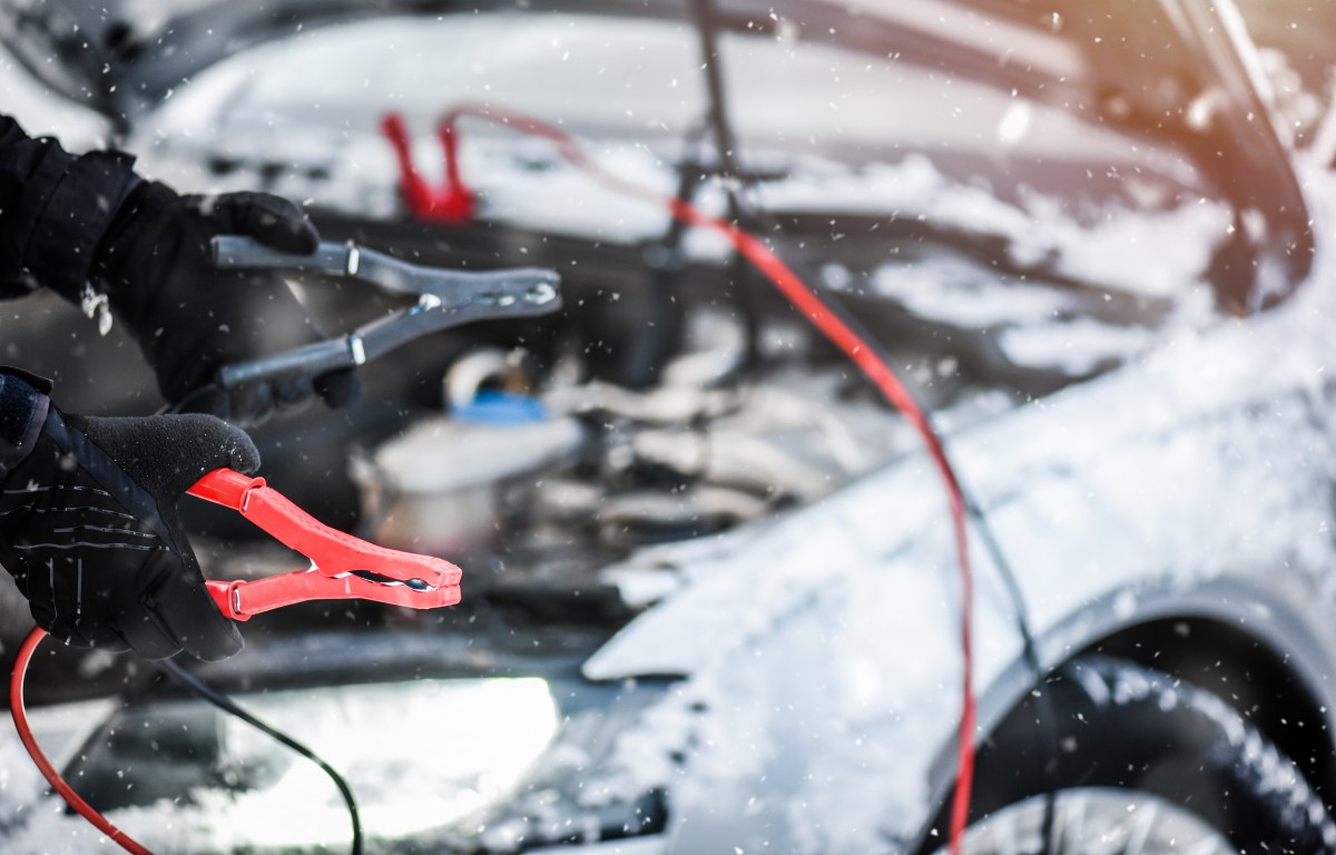 Starthilfekabel an einem verschneiten Auto