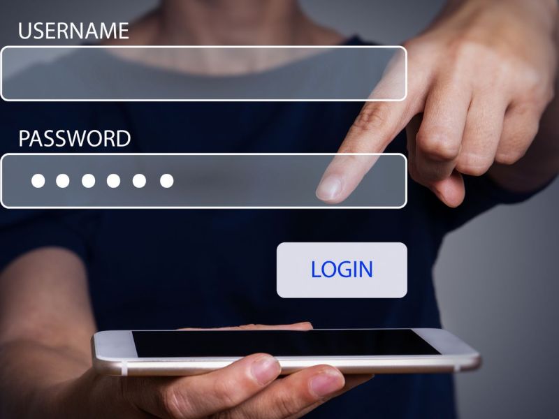 Mann zeigt mit Finger auf Handy, darüber sind Eingabemasken für Username und Passwort zu sehen.