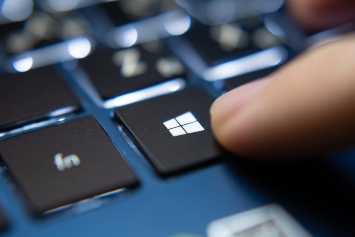 Finger zeigt auf Windows Taste an der Laptop-Tastatur.