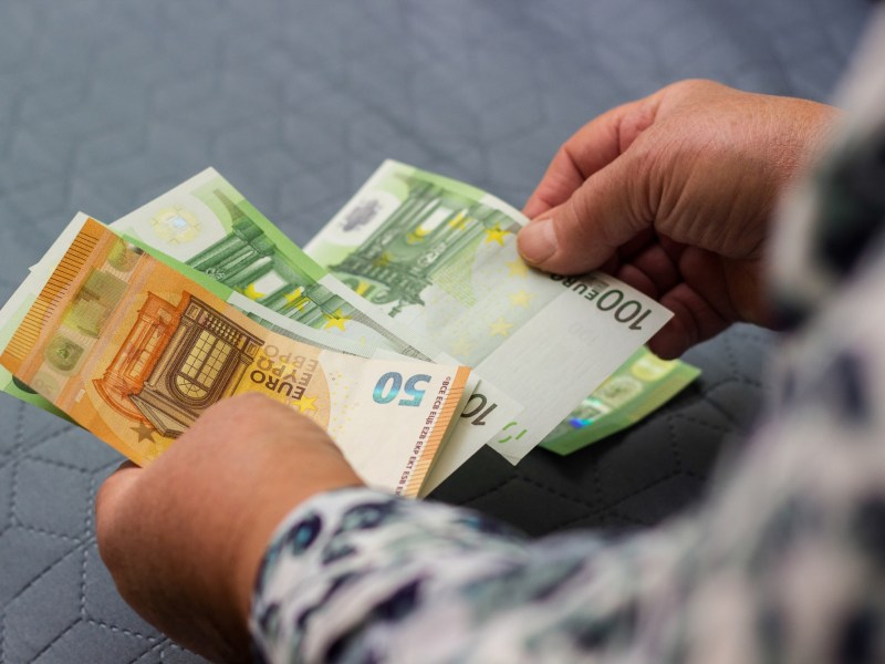 Mann zÃ¤hlt Bargeld in Scheinen