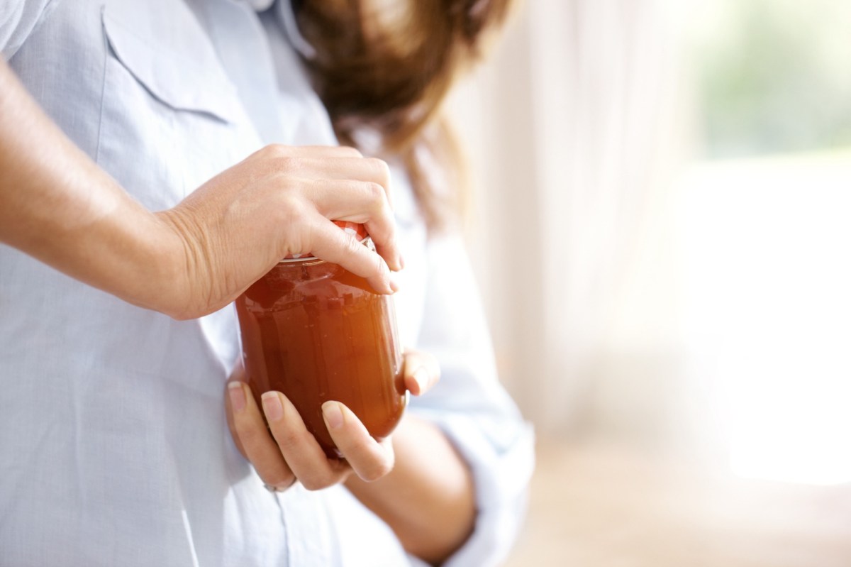 Frau versucht, ein Glas zu öffnen