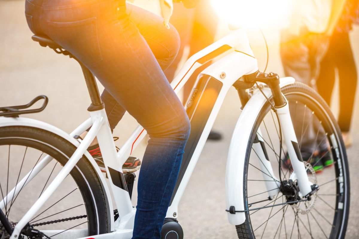 Frau fÃ¤hrt auf einem E-Bike.