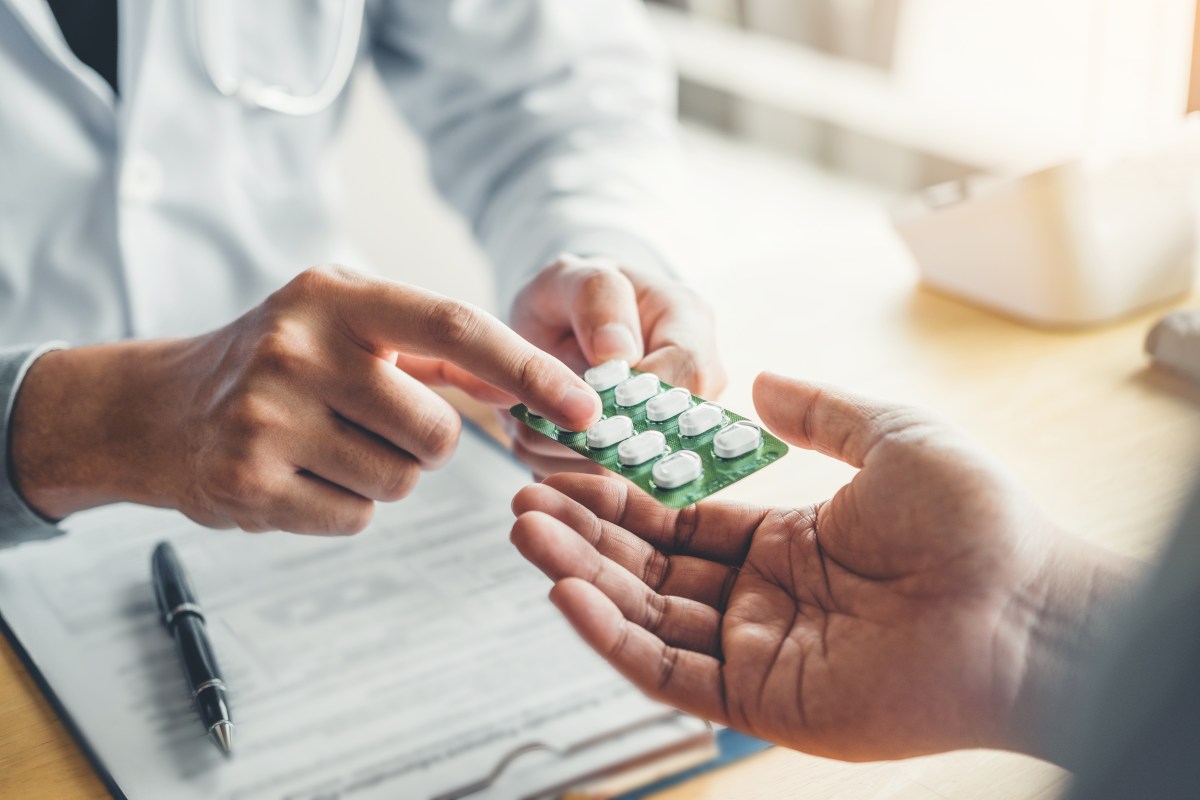 Person übergibt einer anderen eine Tabletten-Packung