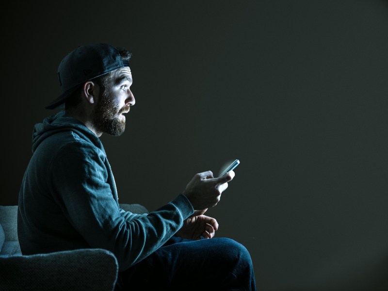 Mann sitzt im Dunkeln vor dem Fernseher