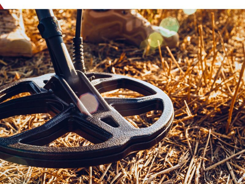 Person mit Metalldetektor in einem Feld