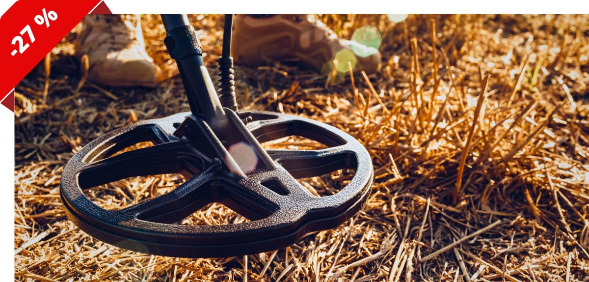 Person mit Metalldetektor in einem Feld