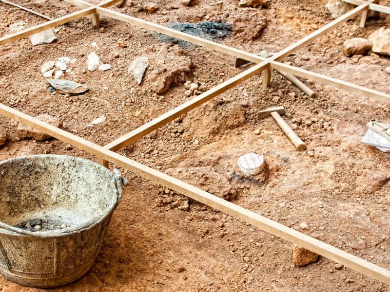 Mehrere archÃ¤ologische Funde verstreut im Sand.