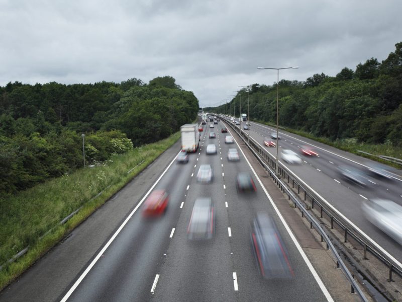 Autos fahren im hohen Tempo über eine Autobahn.