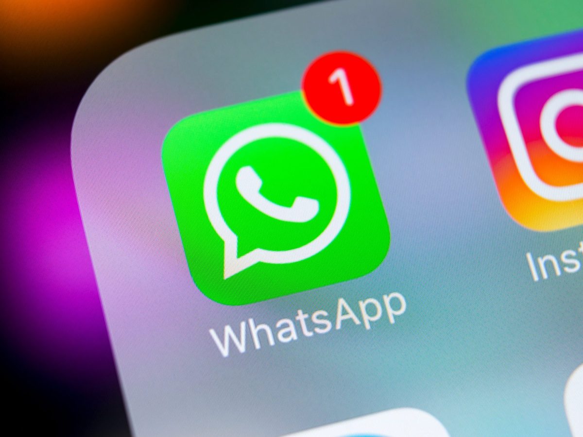 Auf einem Handydisplay wird das WhatsApp-Logo angezeigt.