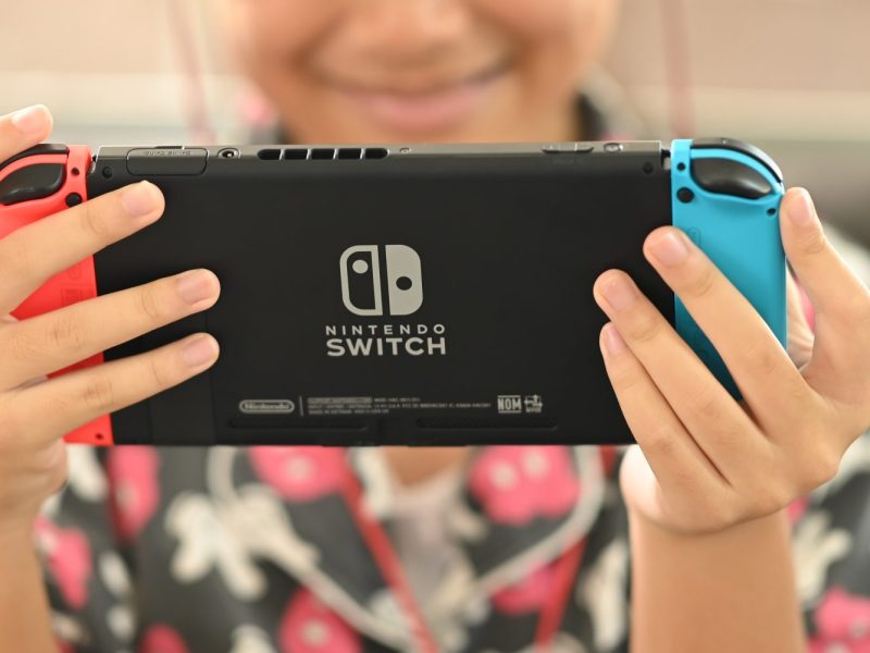 Person hält Nintendo Switch Konsole in den Händen.