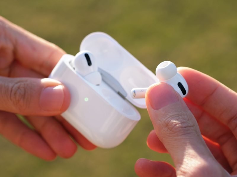 Person hÃ¤lt Apple Airpod aus dem Lade-Case.