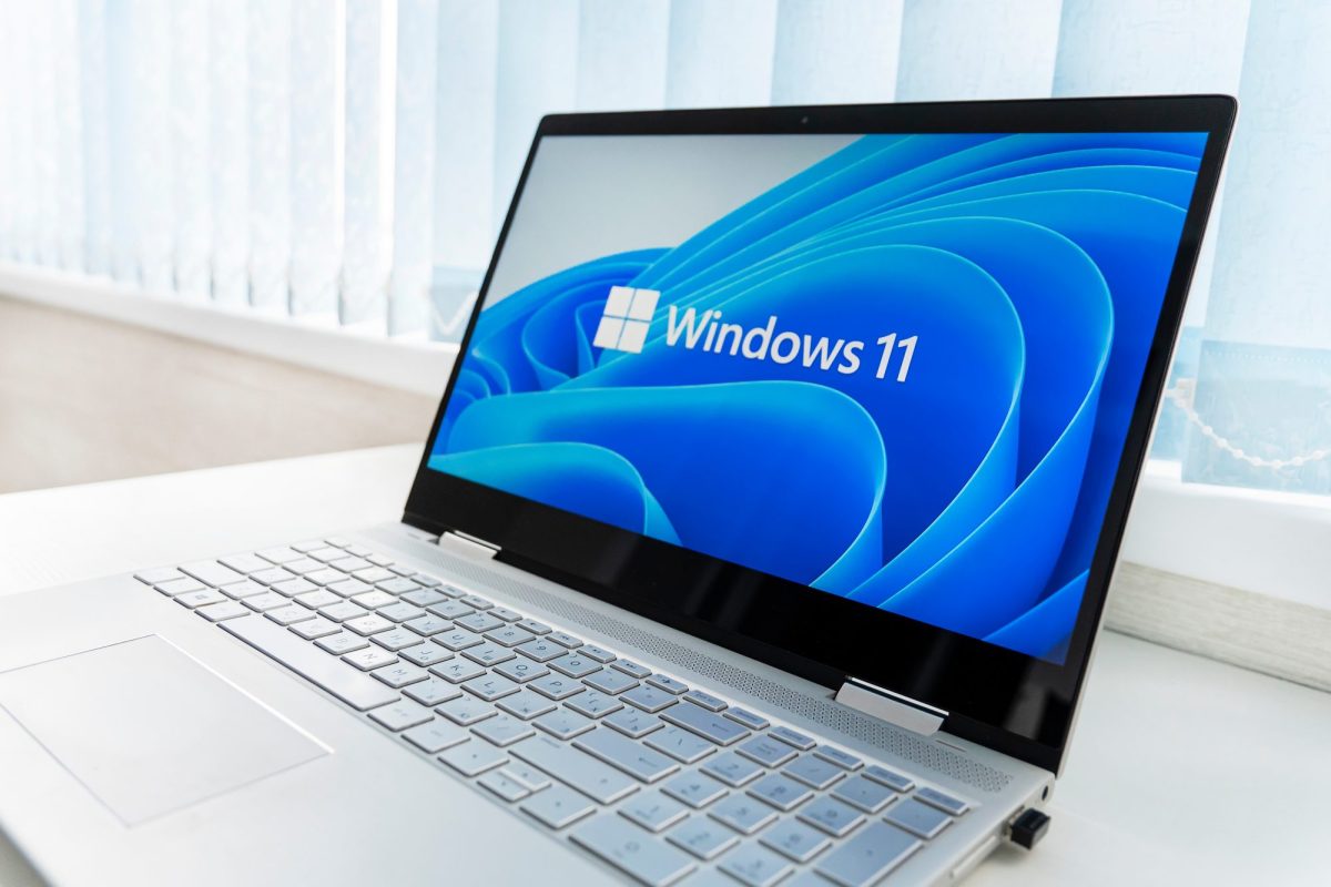 Auf einem dem Bildschirm eines aufgeklapptem Laptop wird das Windows 11-Logo angezeigt.