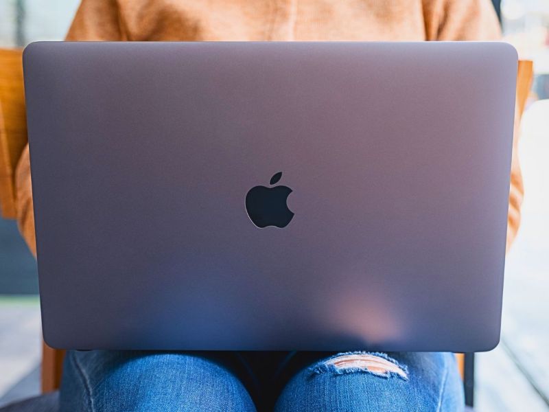 MacBook von Apple auf dem SchoÃŸ einer Frau.