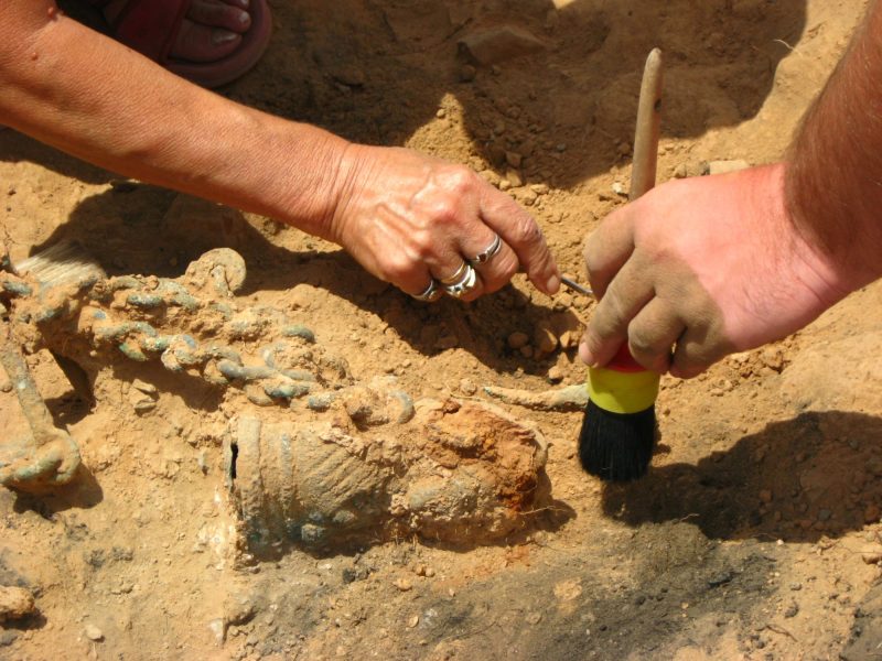 Menschen arbeiten mit Werkzeug an einem archÃ¤ologischen Fund.