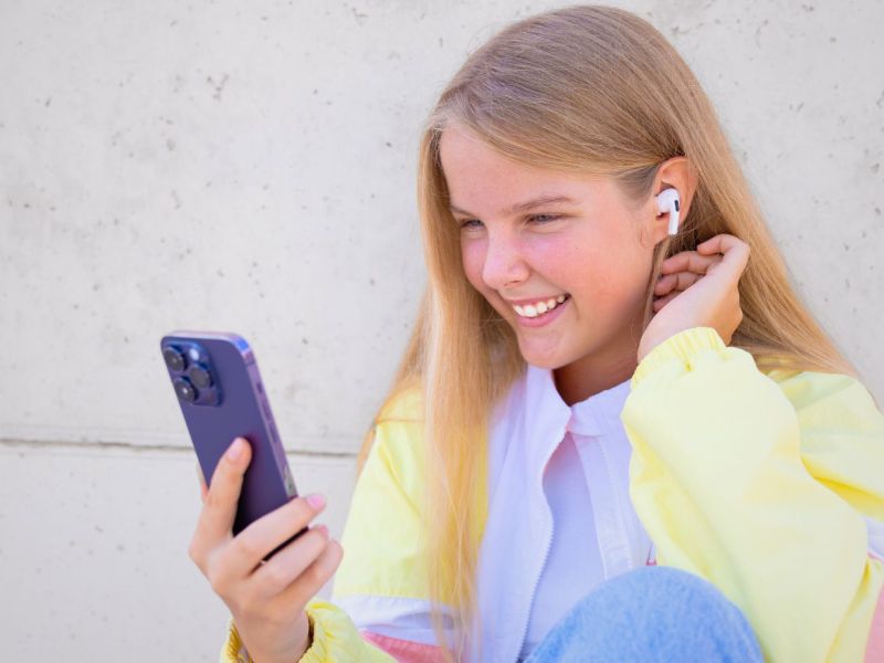 MÃ¤dchen nutzt iPhone mit AirPods