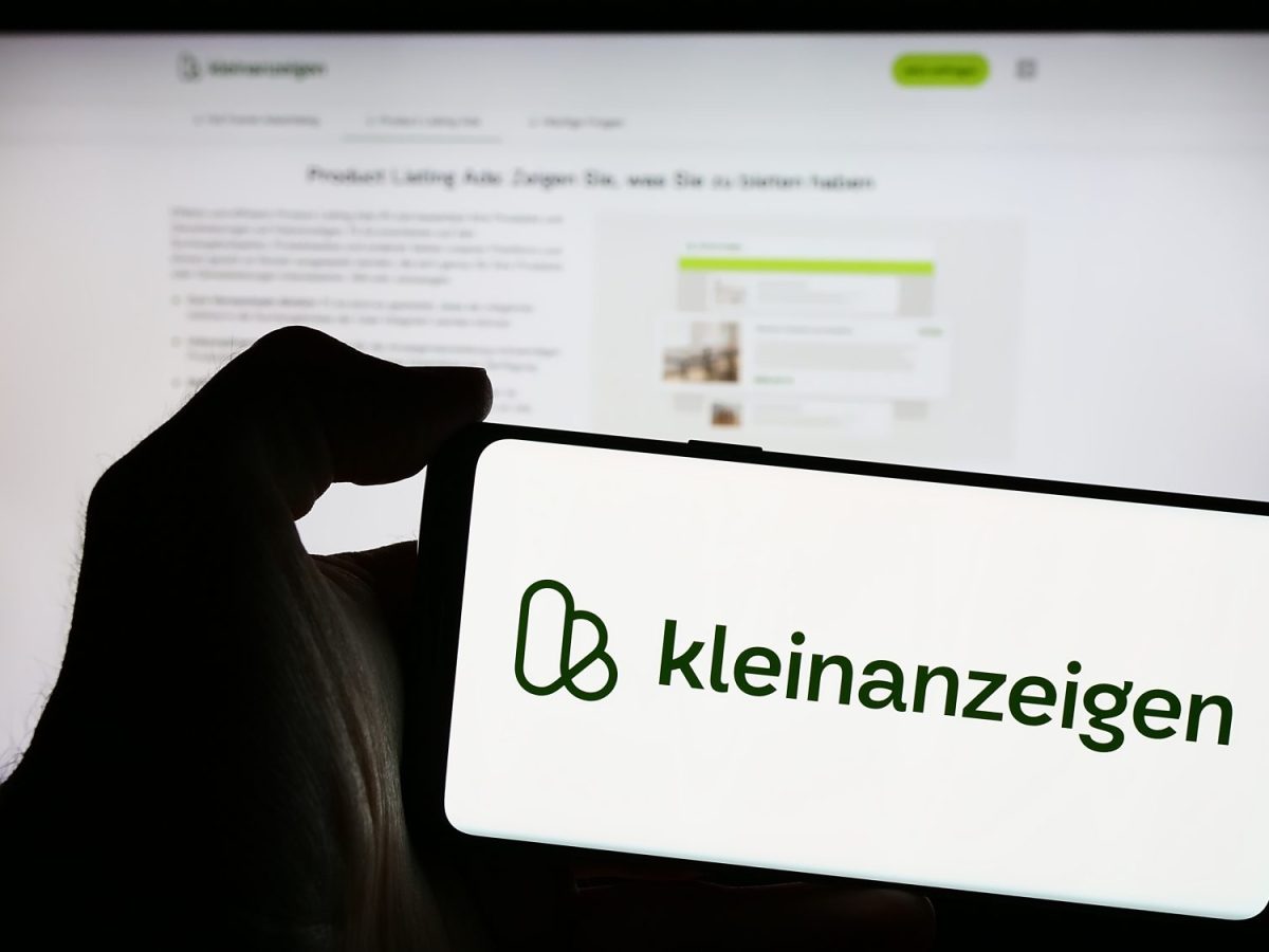 Person hÃ¤lt ein Smartphone in der Hand, auf dem Bildschirm ist das Logo von Kleinanzeigen zu sehen,