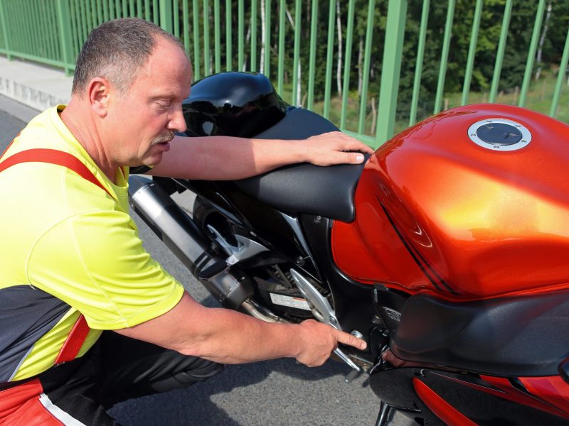 Mann fÃ¼hrt den TÃœV beim Motorrad durch.