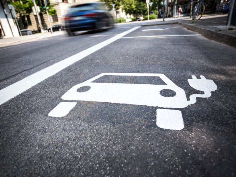 Zeichen fÃ¼r ein Parkplatz zum Elektroauto laden am StraÃŸenrand.