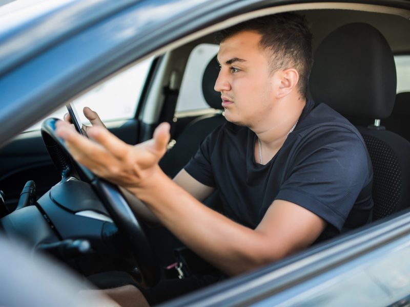 Autofahrer sitzt im Auto und macht eine unglÃ¤ubige Geste.