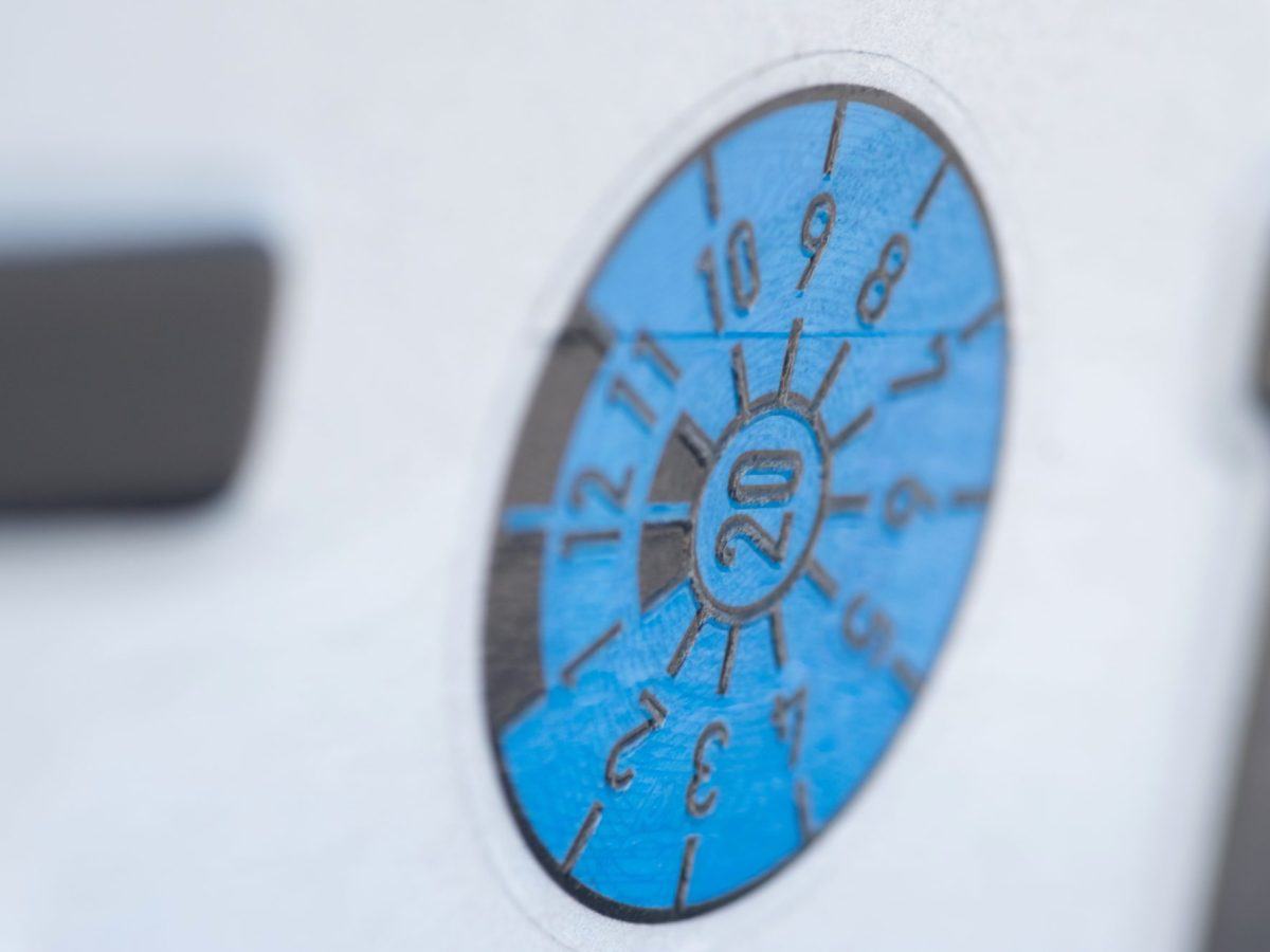 TÜV-Plakette an einem Auto.
