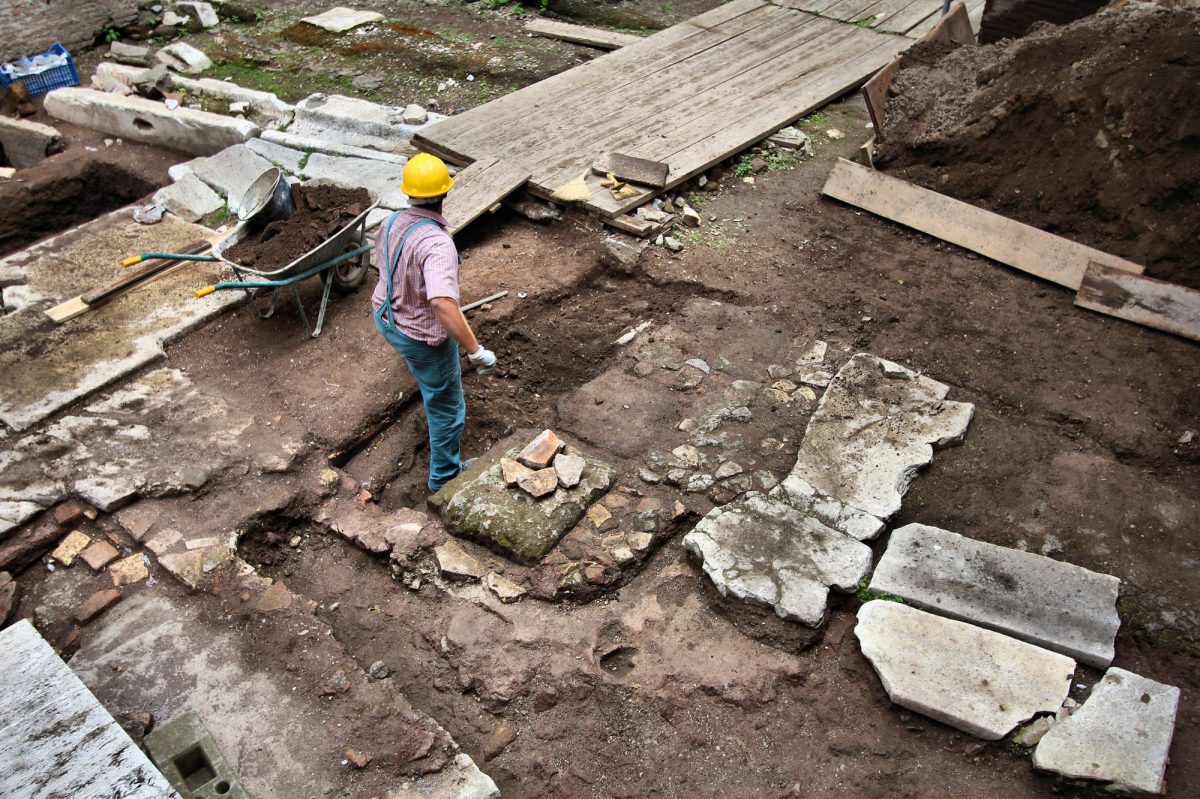 MÃ¤nner arbeiten an einem archÃ¤ologischen Fund.