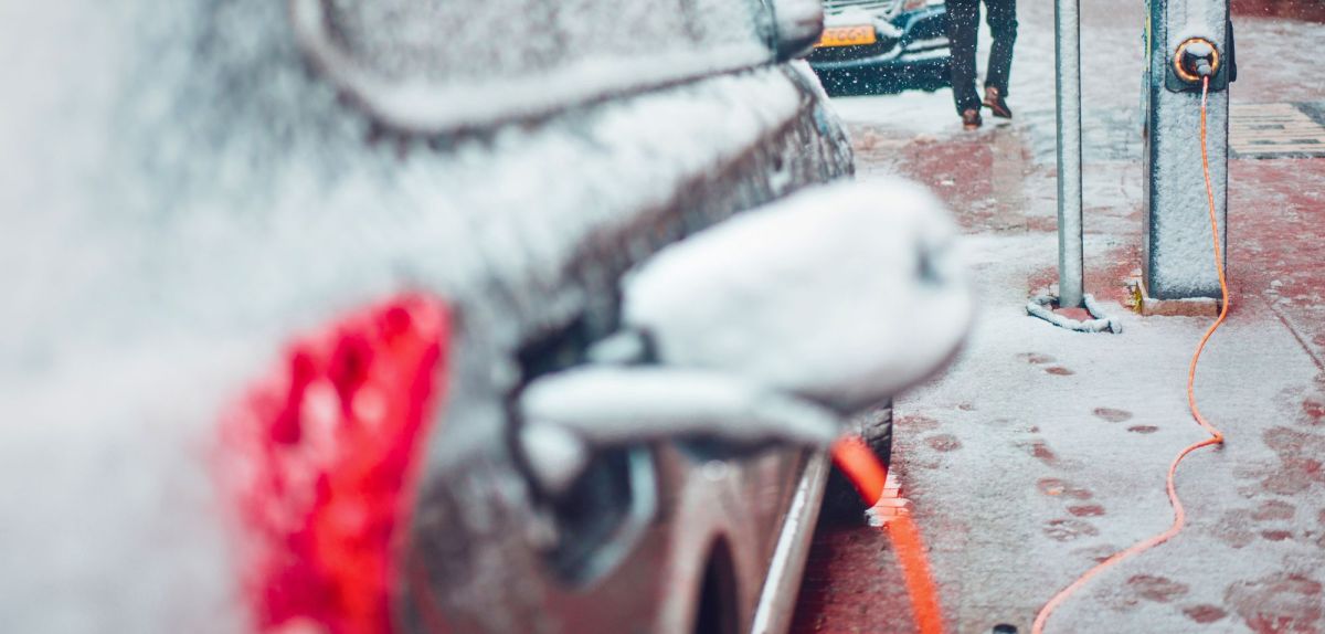 Schneebedecktes Elektroauto an einer LadesÃ¤ule