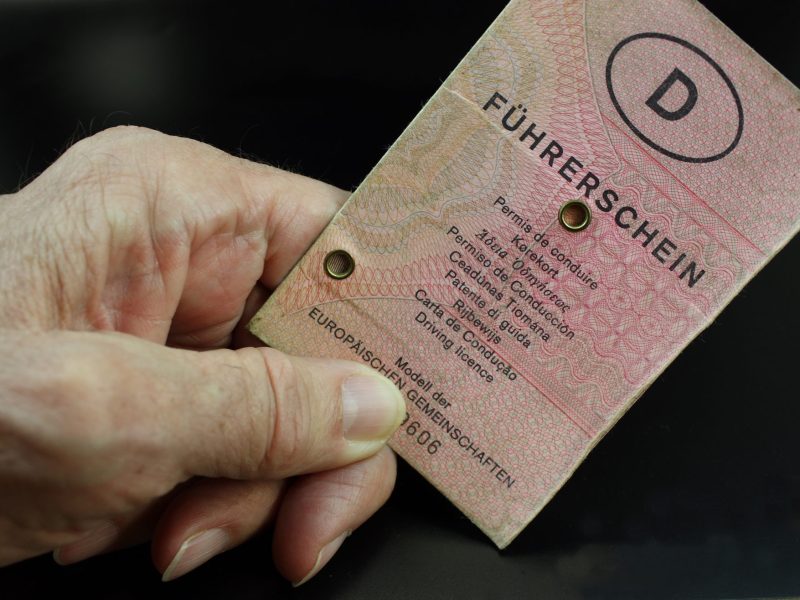 Hand einer Ã¤lteren Person hÃ¤lt altes FÃ¼hrerschein-Dokument in der Hand.