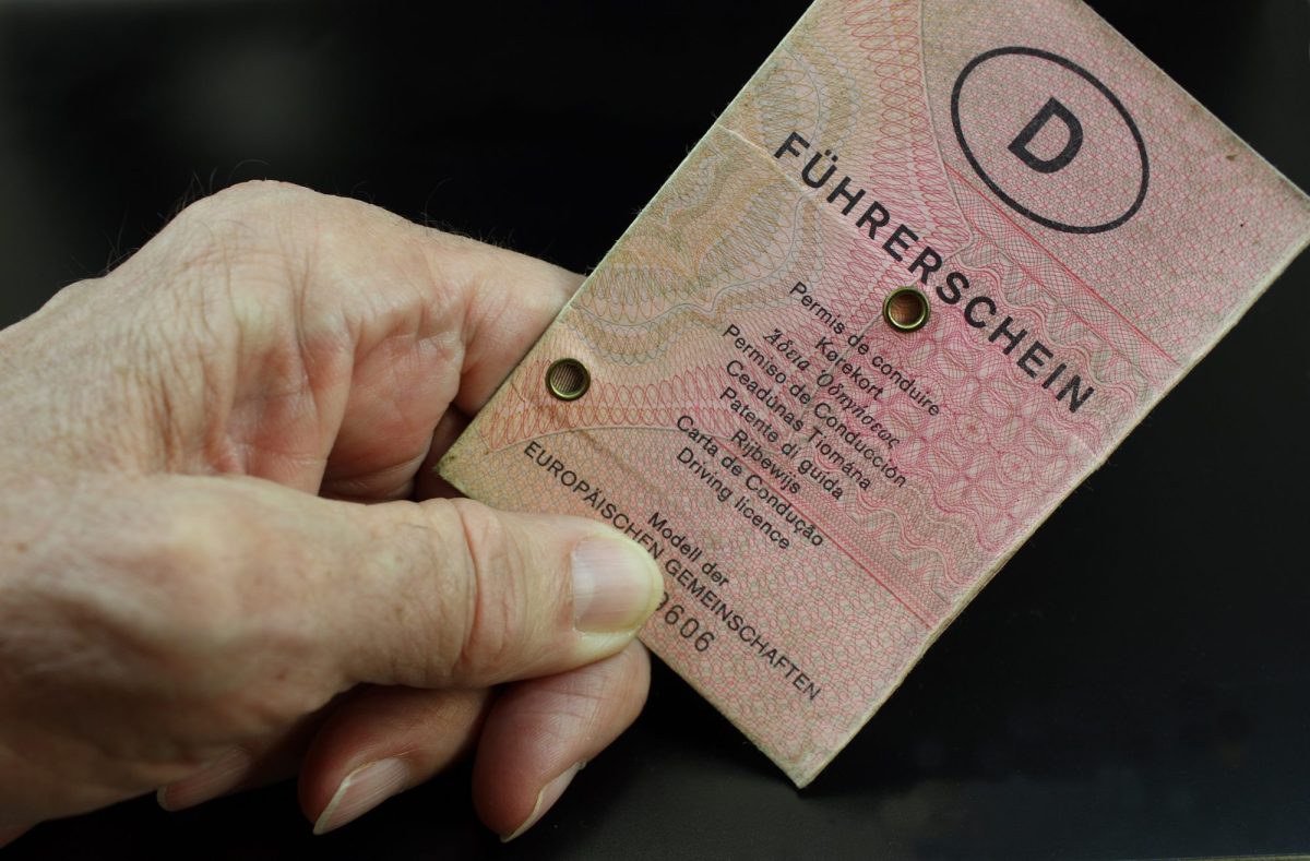 Hand einer Ã¤lteren Person hÃ¤lt altes FÃ¼hrerschein-Dokument in der Hand.