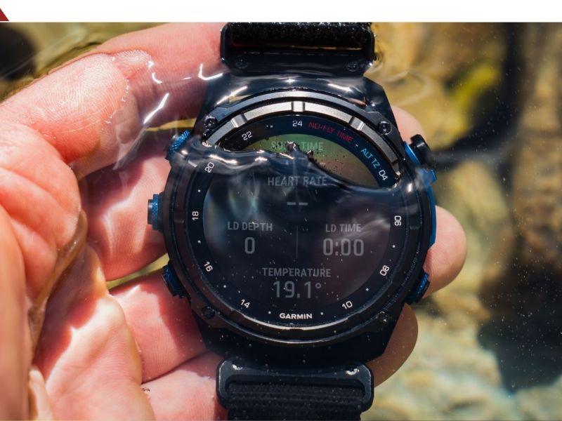 Person hÃ¤lt eine Garmin-Smartwatch ins Wasser.