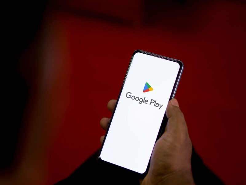 Person hÃ¤lt ein Handy in der Hand. Auf dem Display wird der Google Play Store angezeigt.